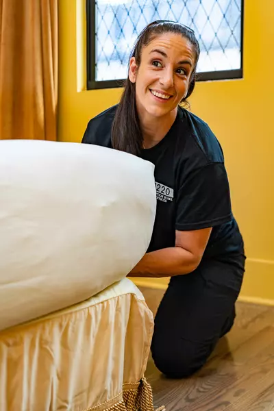 person putting sheets on mattress