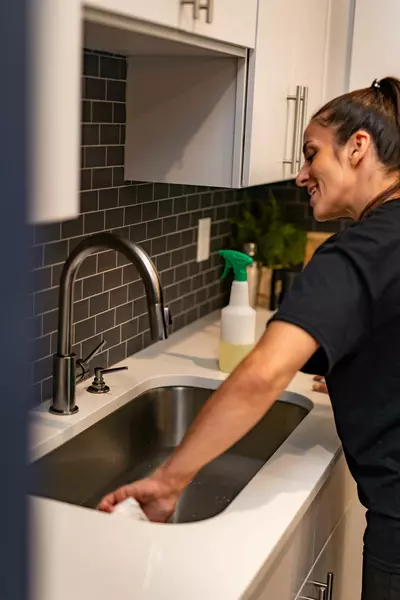 person cleaning kitchen sink