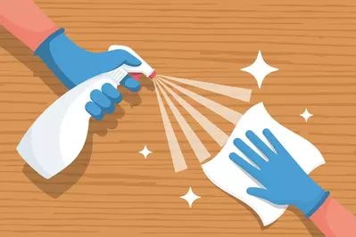 illustration of gloved hands cleaning with a rag and spray